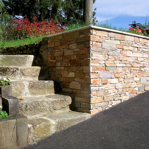 Placage de pierre sur muret à côté d'un escalier de pierre