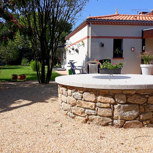 Montage d'un puits en pierres naturelles devant une maison à Clisson