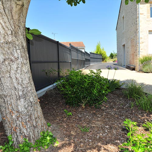 Massif aménagé avec arbres, arbustes et copeaux de bois près de Cholet